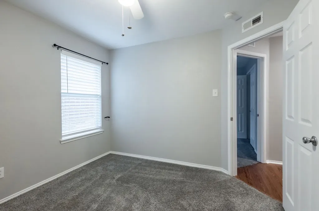 Gray carpeting and a ceiling fan with light fixture