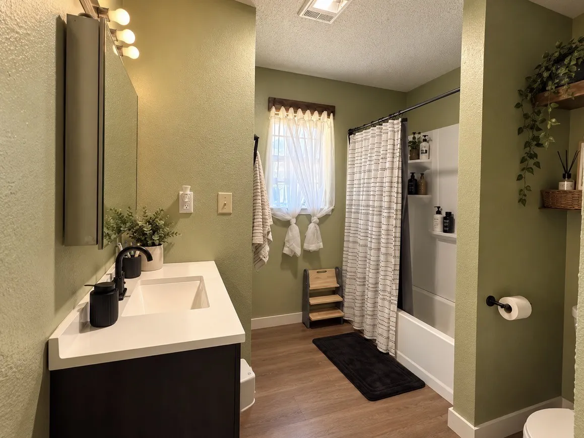 Bathroom featuring a vanity with an integrated sink, black fixtures, and a medicine cabinet