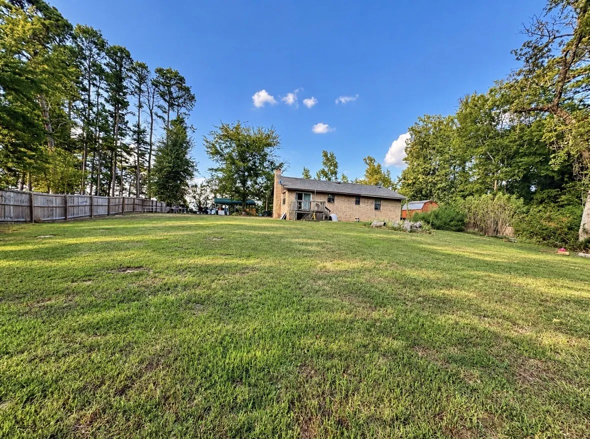 Expansive grassy lawn with a wood privacy fence
