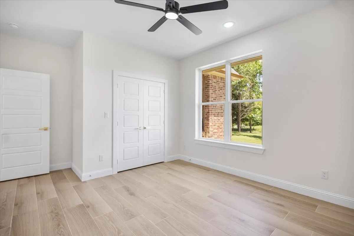 Wood-finish flooring, white paneled doors, recessed lighting, and a modern ceiling fan