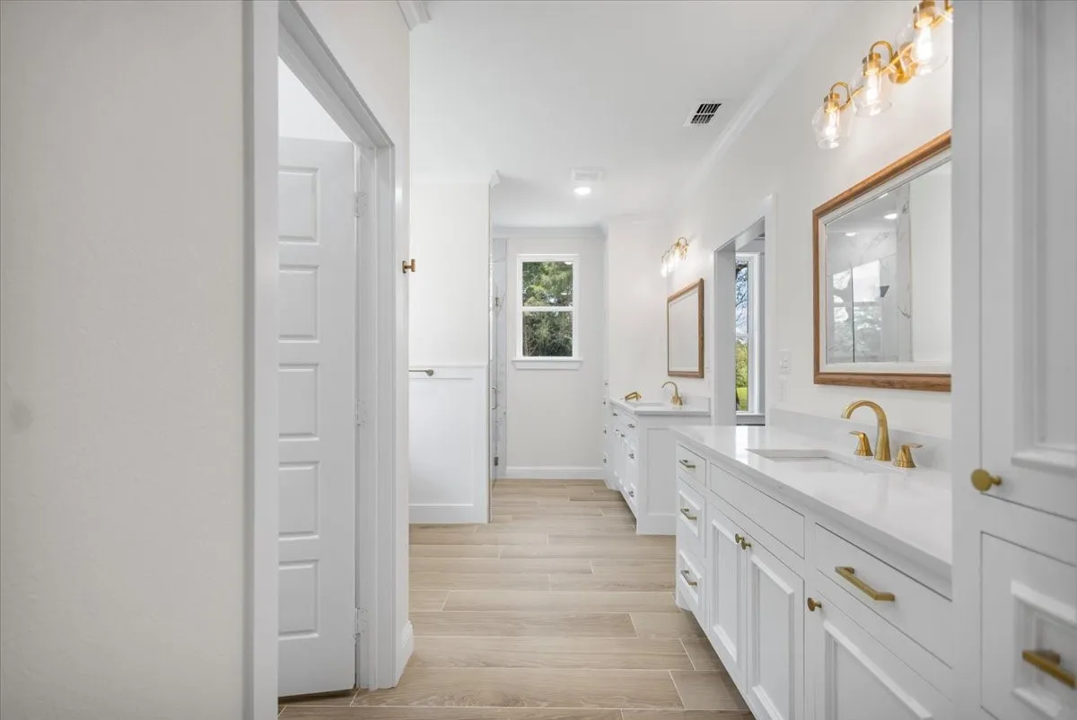 Dual vanity with white cabinetry and gold-tone hardware