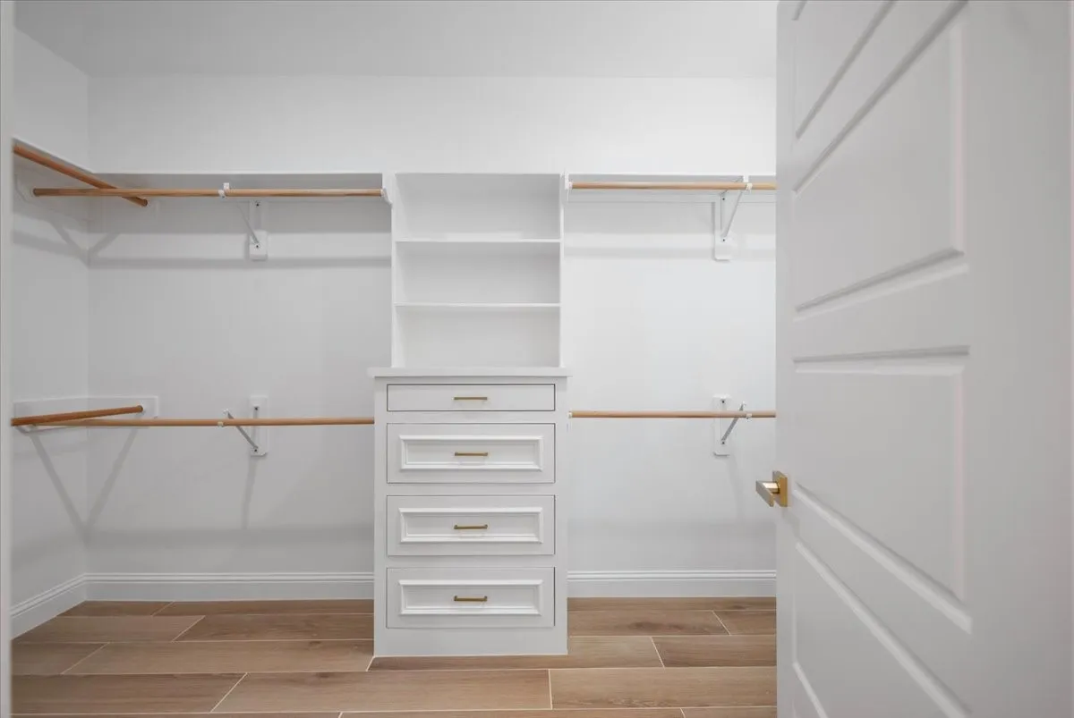 Custom built-in storage with drawers, open shelving, and hanging rods