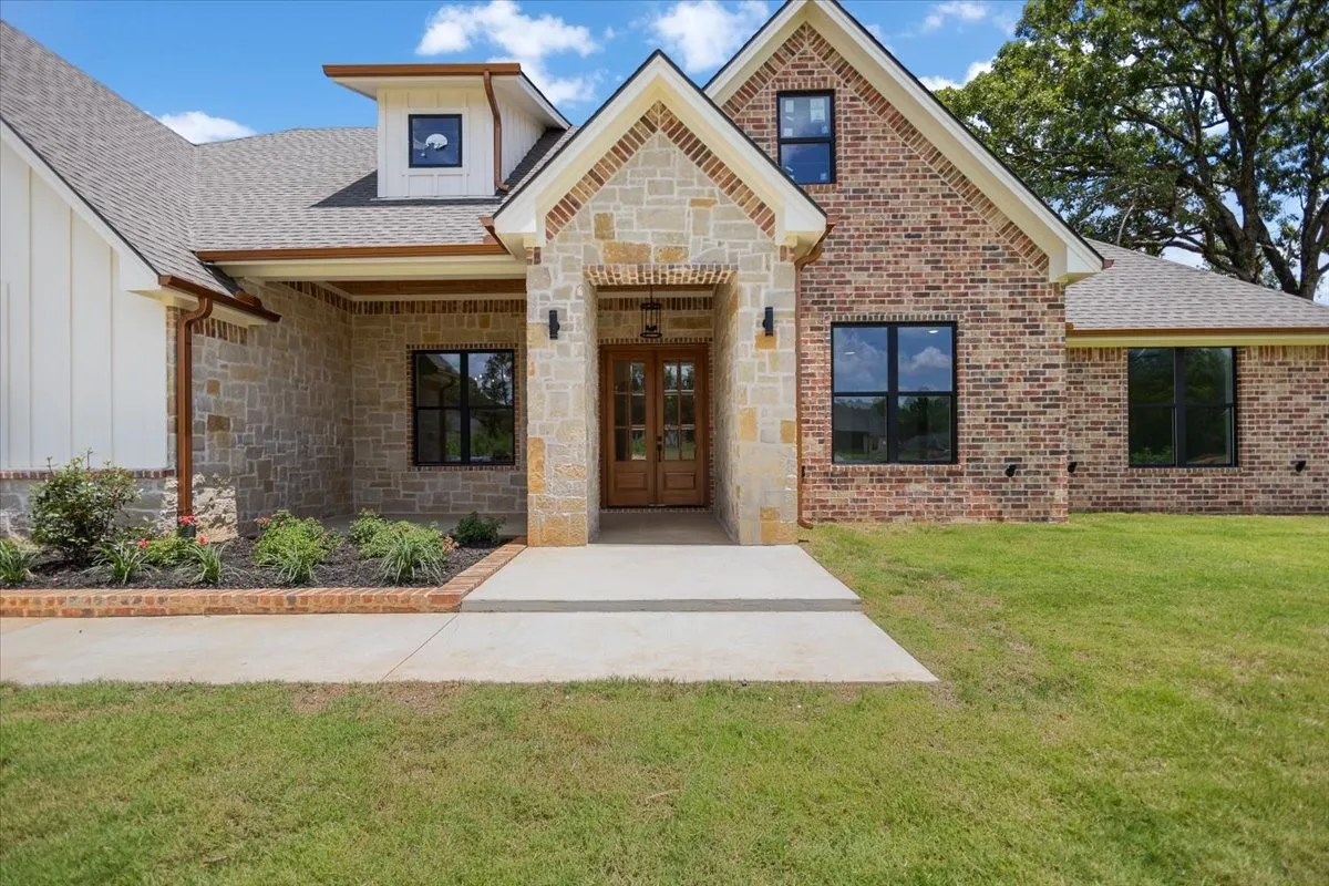 Stone and brick exterior with wood-finish double entry doors