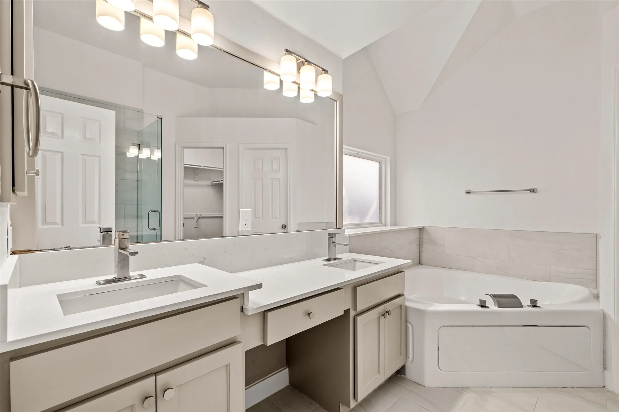 Dual vanity with undermount sinks, white countertop, and integrated storage cabinetry