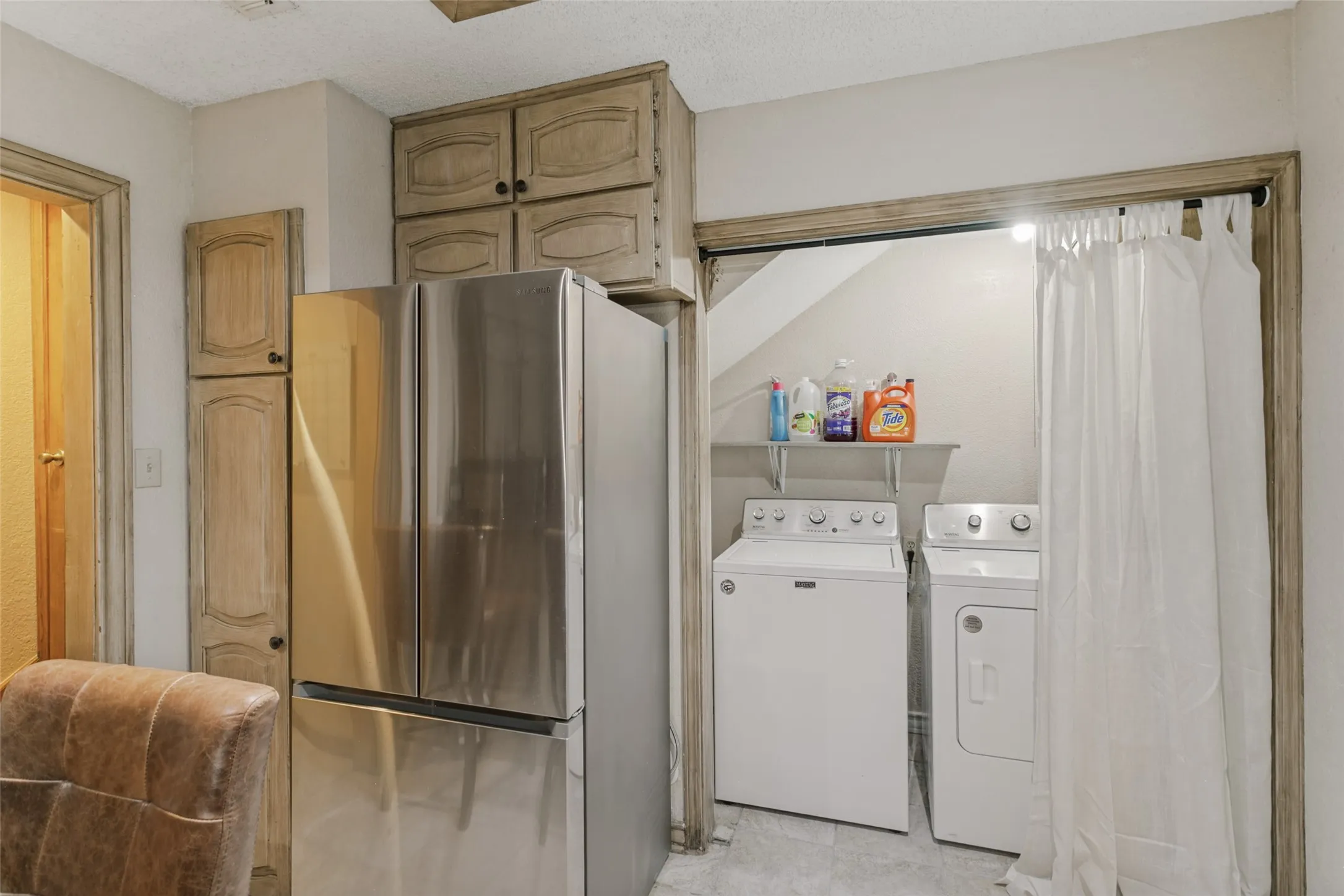 Integrated laundry area with shelving and a full-size washer and dryer