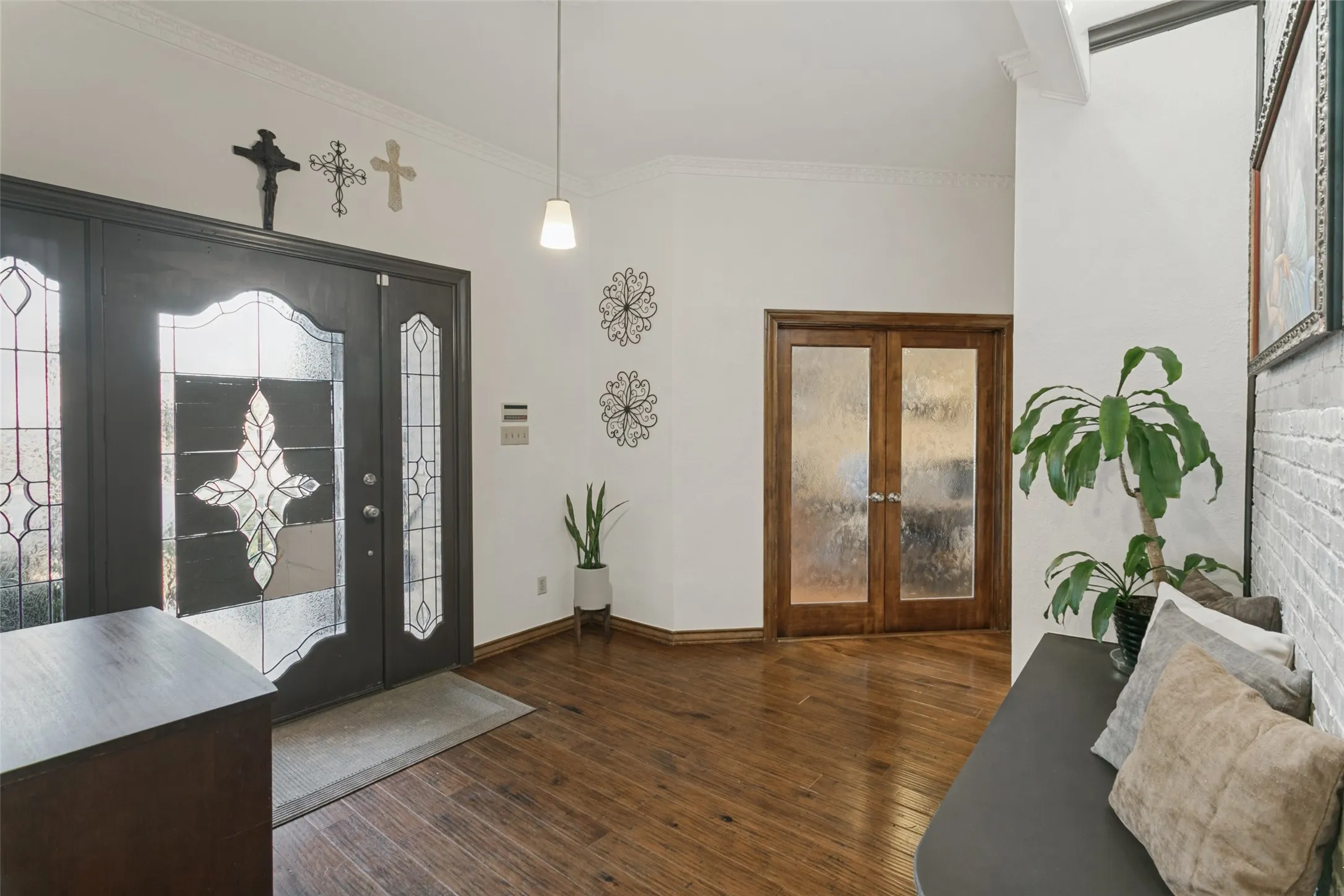Entryway featuring wood-finish flooring, a double entry door with decorative glass, and a pendant light fixture