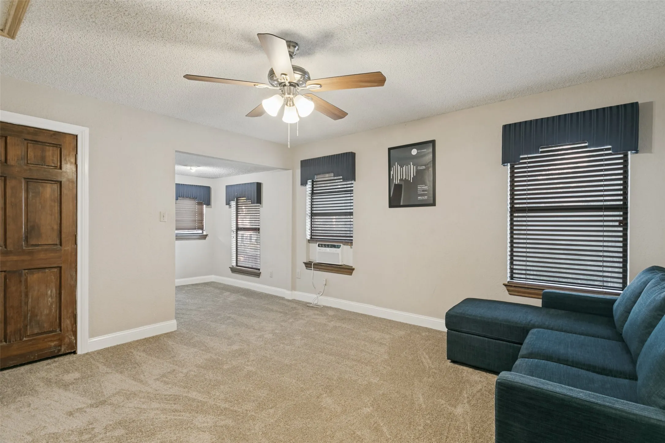 Upstairs bedroom features Wall-to-wall carpeting with light-toned walls, a decorative ceiling fan, and paneled wood doors