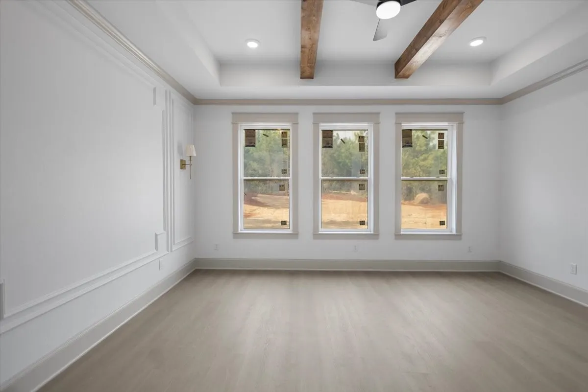 Tray ceiling with recessed lighting and exposed wood beams