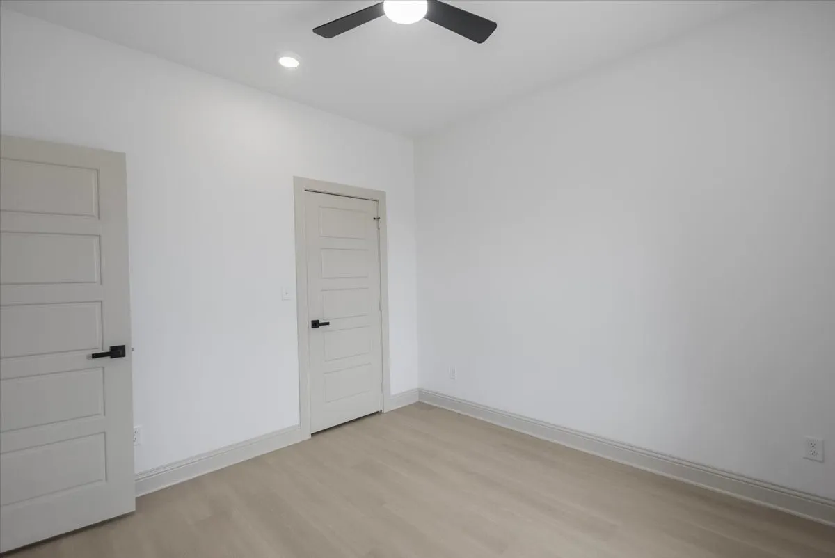 Recessed lighting, ceiling fan, five-panel interior doors, modern black hardware, wood-finish flooring