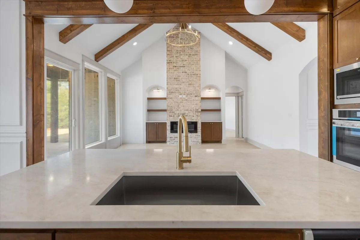 Kitchen island featuring a built-in sink with a gold-finish faucet