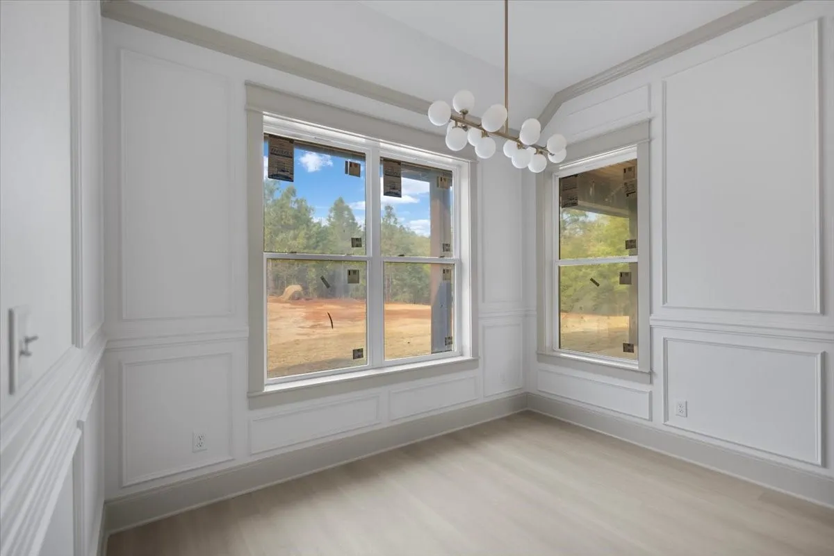 Wood-finish flooring with elegant wainscoting and crown molding