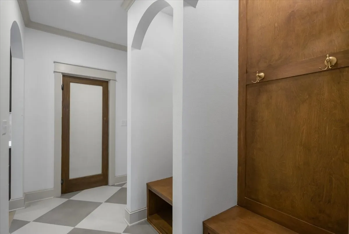 Arched doorways, recessed lighting, and checkerboard floor tiling