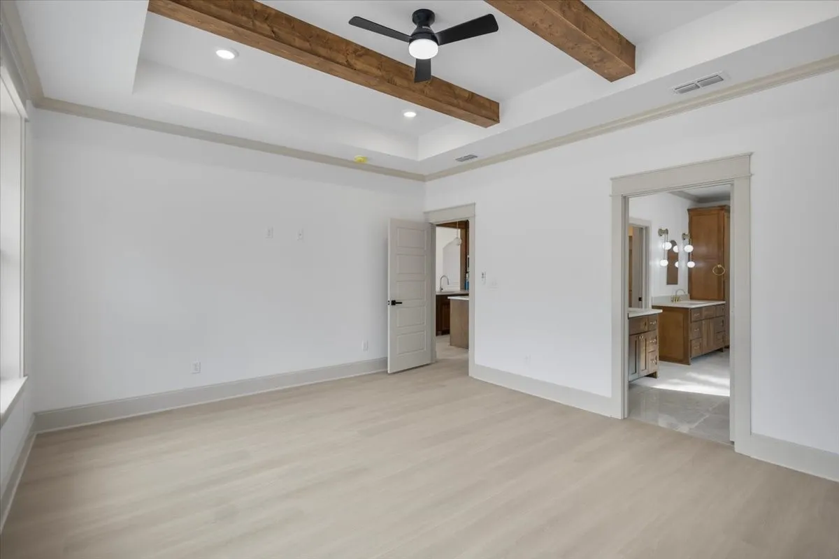Tray ceiling with recessed lighting and wood-finish beams