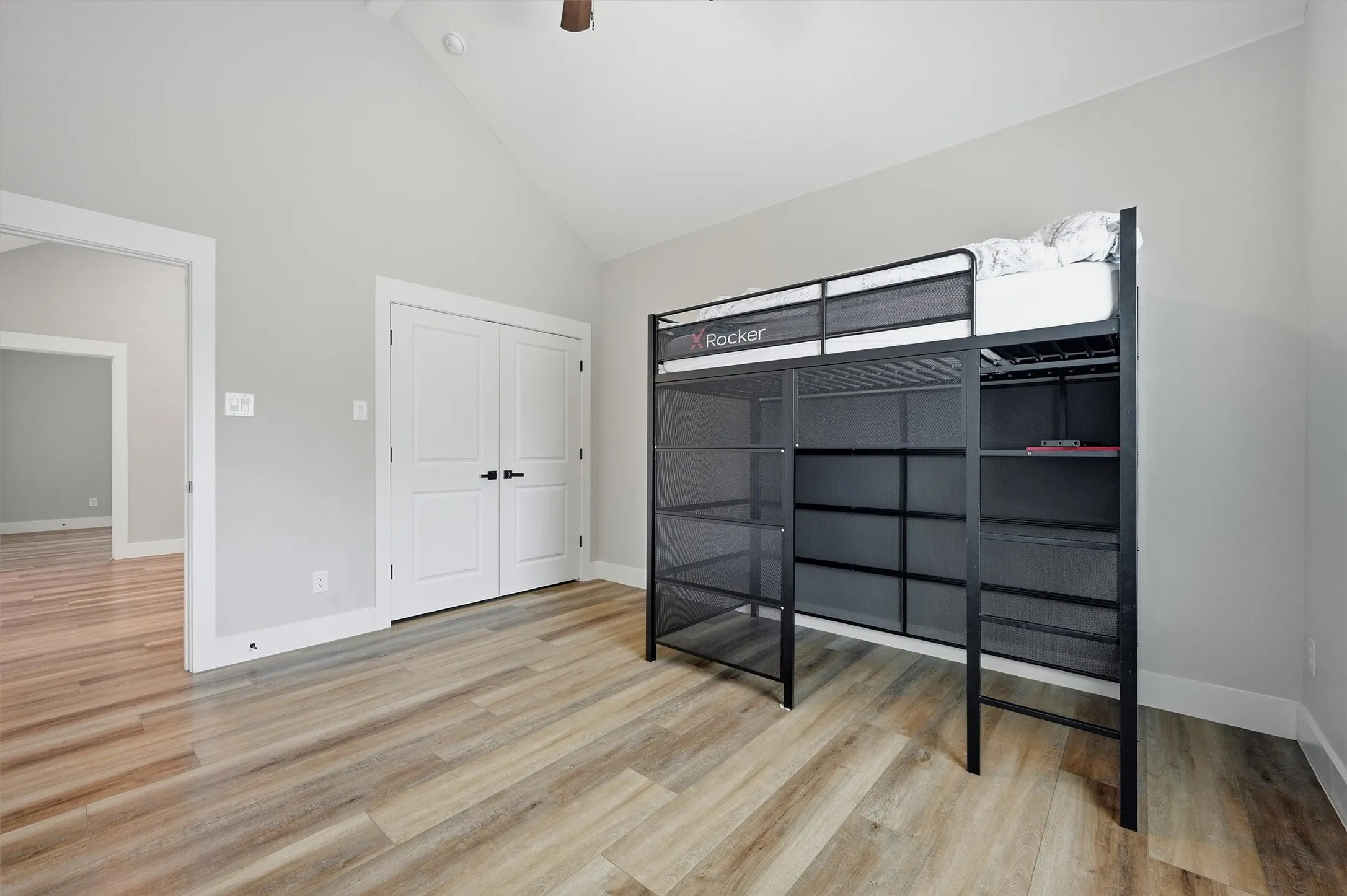 Vaulted ceiling, wood-finish flooring, and white trim