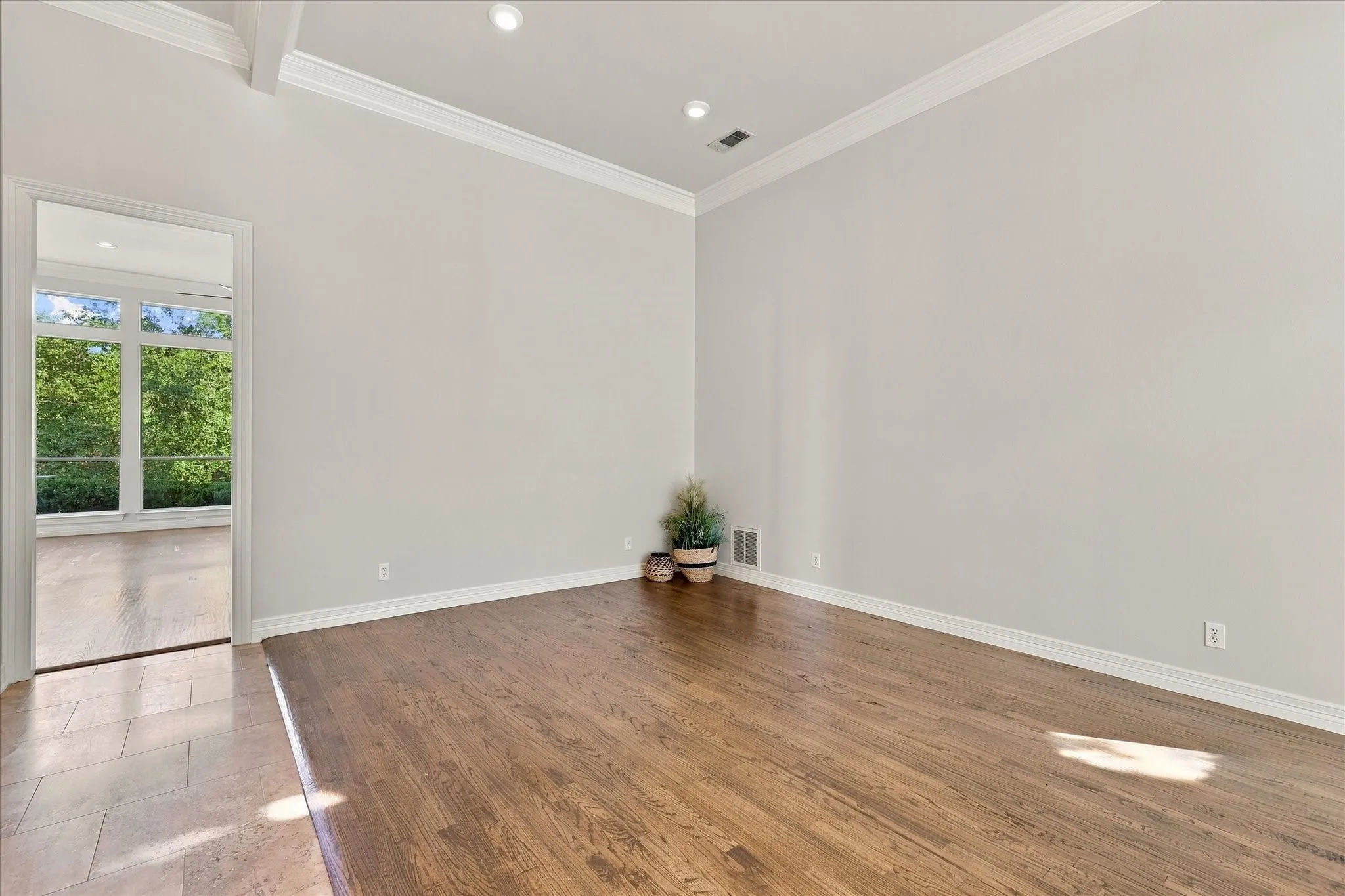 Hardwood flooring, crown molding, recessed lighting, and a vaulted ceiling