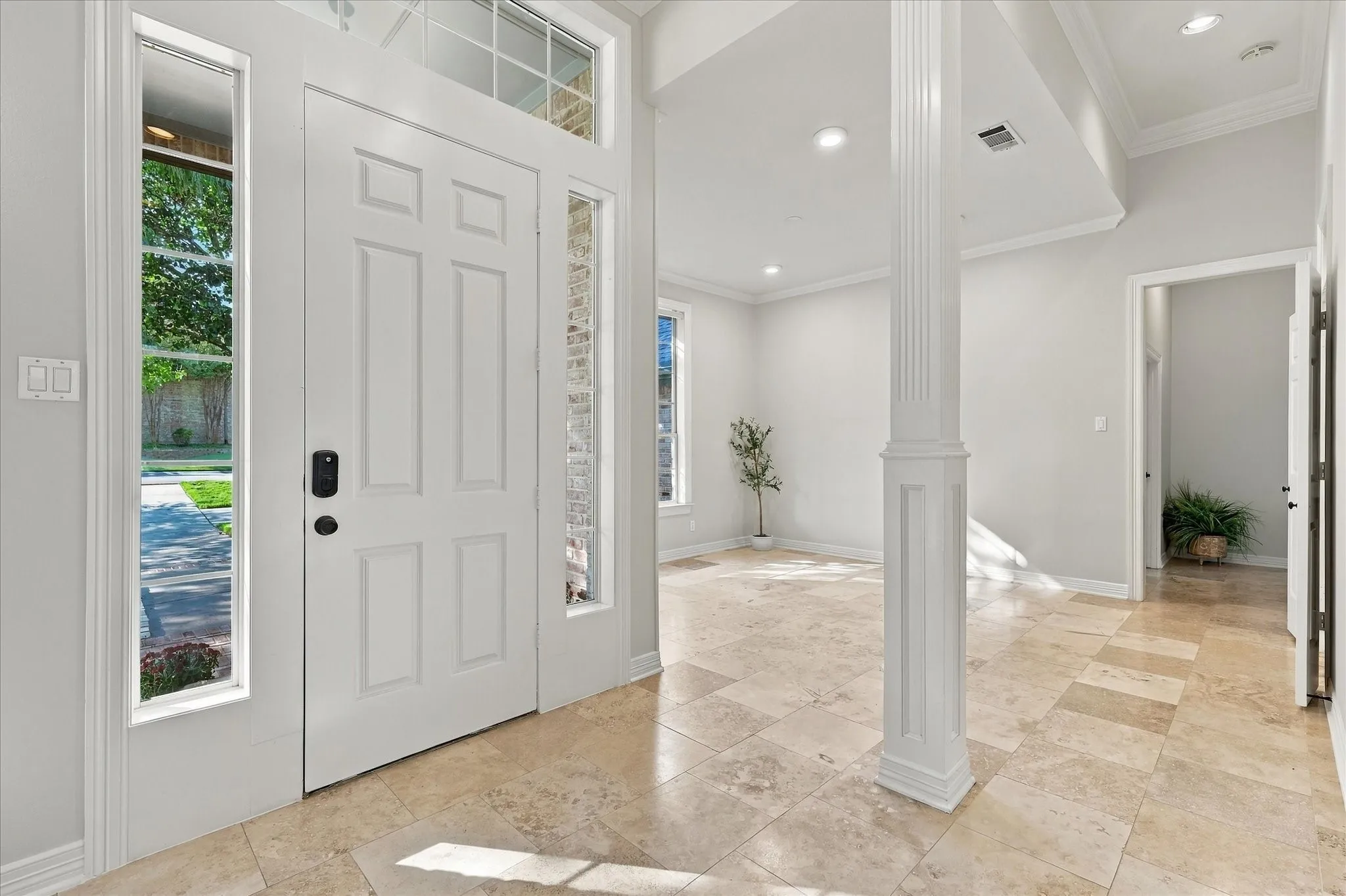 Entryway with a paneled door, transom window, and sidelights