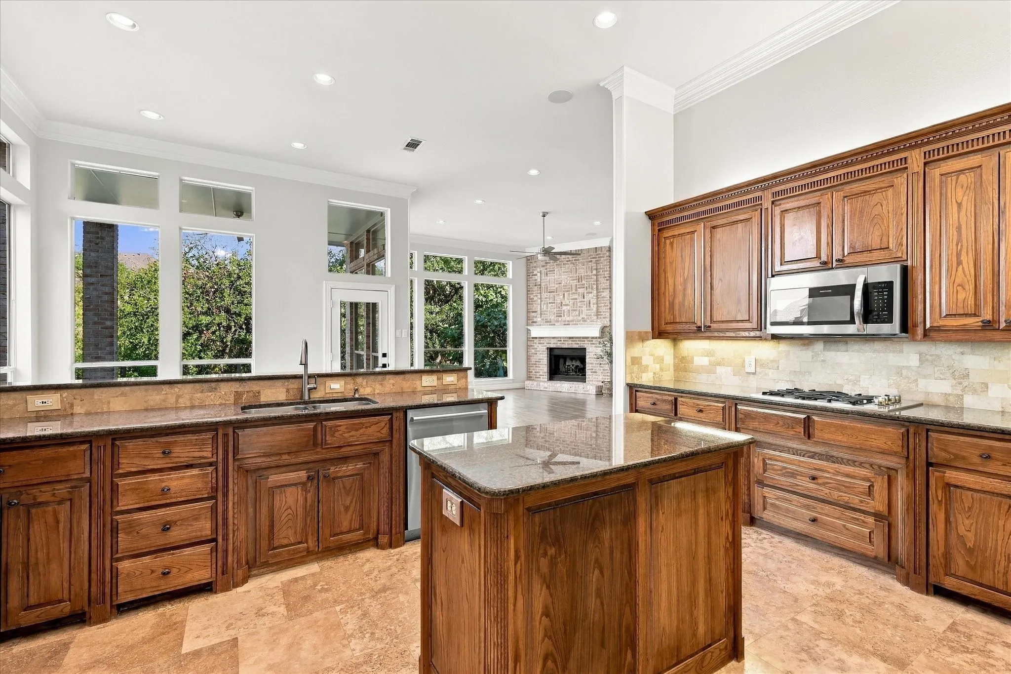 Kitchen featuring wood cabinetry, stainless steel appliances, a center island with a granite countertop, and tiled flooring