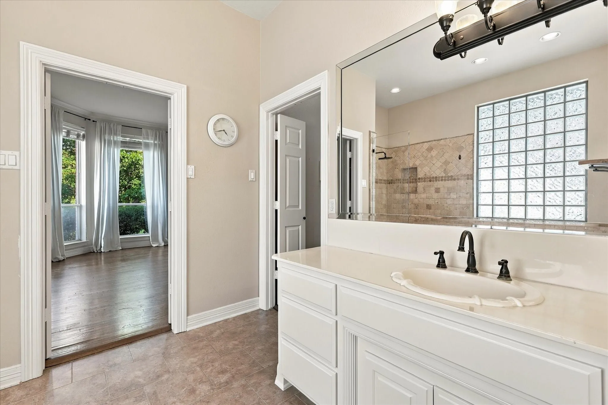 White vanity with a light-colored countertop and integrated sink