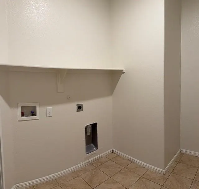 Laundry area featuring a built-in shelf, neutral wall tones, and tiled flooring