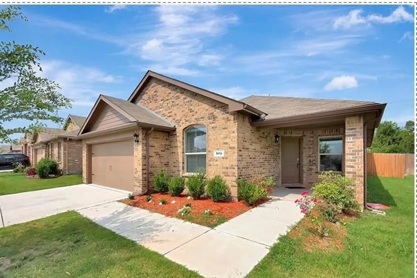 Brick facade residence featuring an attached garage, arched window, and front porch entry