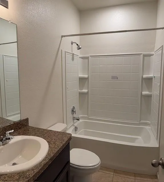 Bathroom featuring a white bathtub and shower combination with integrated shelving, a chrome showerhead, and a matching chrome faucet