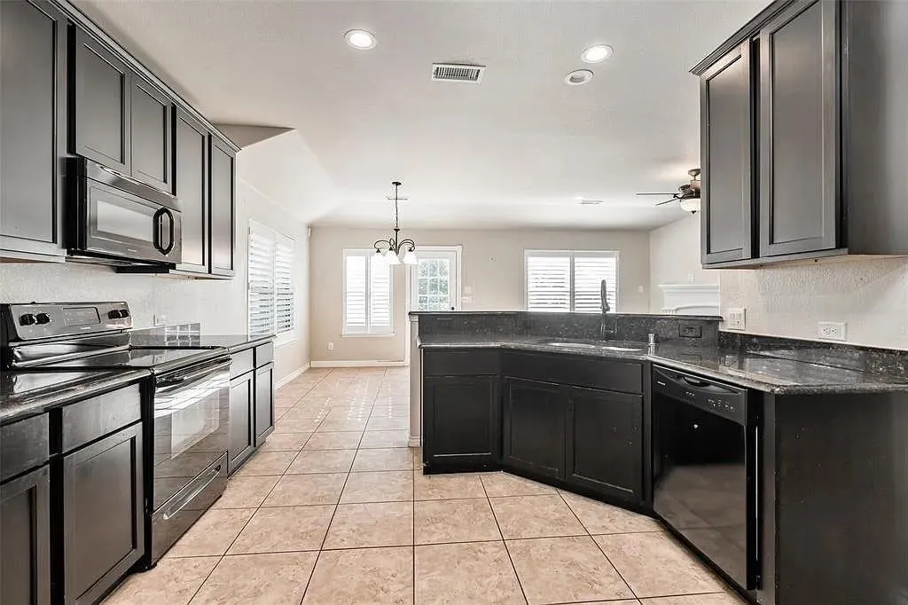Kitchen featuring tile flooring, dark cabinetry, dark countertops, and stainless steel appliances