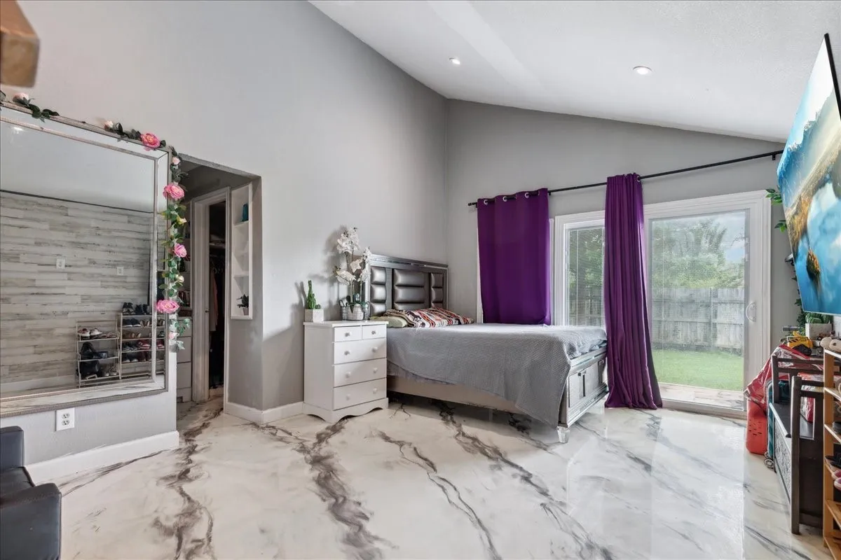 Vaulted ceiling, recessed lighting, sliding glass door, patterned tile flooring, and built-in closet shelving