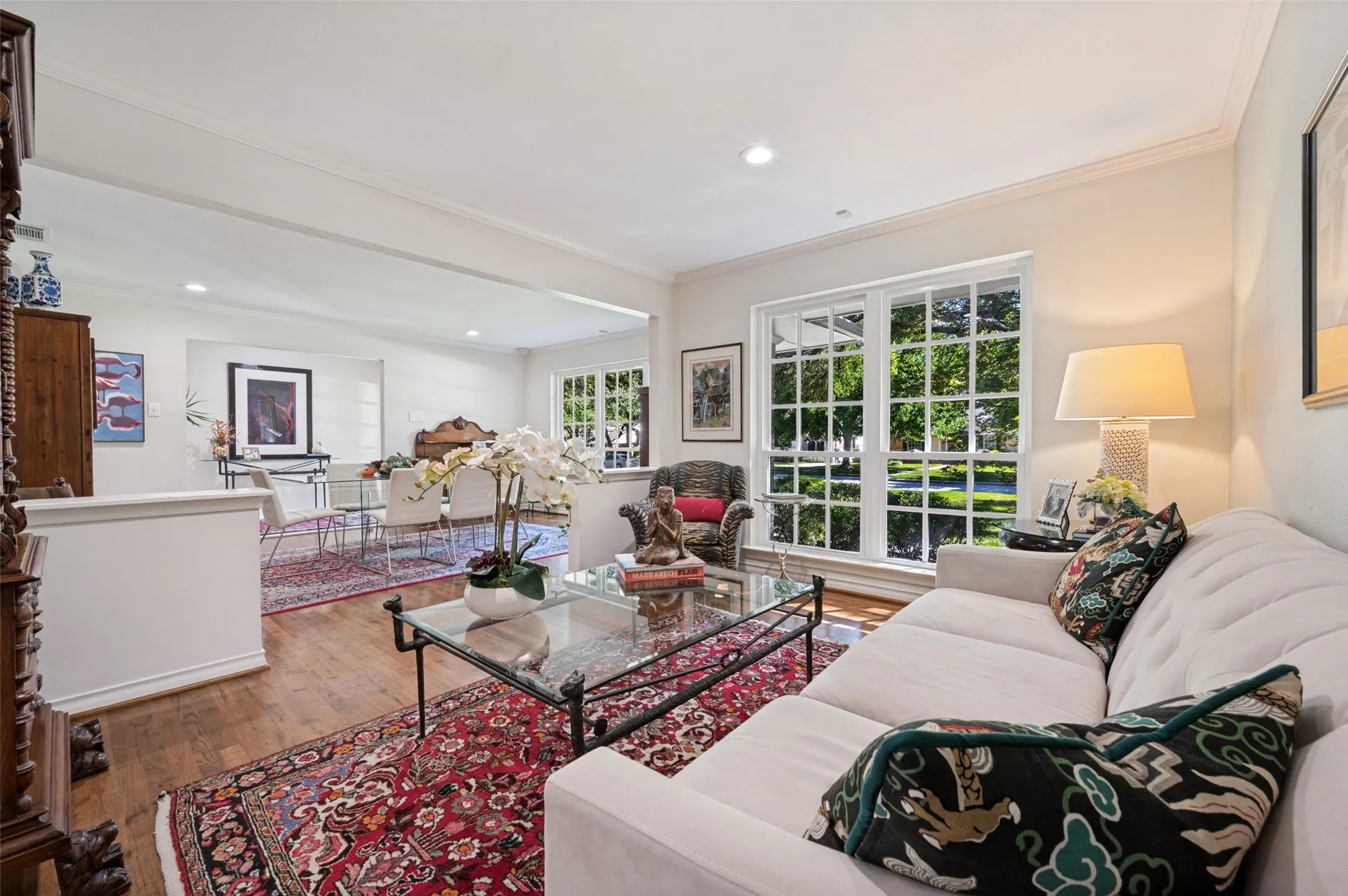 Hardwood flooring throughout the main living areas, complemented by large paneled windows, recessed lighting, and crown molding