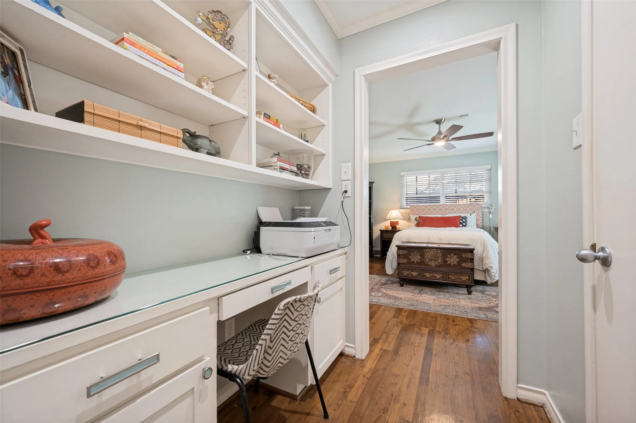 Built-in shelving, integrated desk, and wood flooring