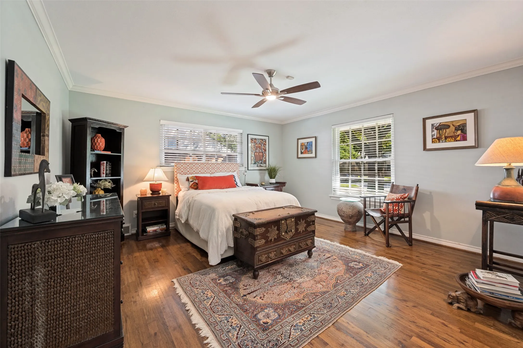 Hardwood flooring, ceiling fan, crown molding, and multiple windows with blinds