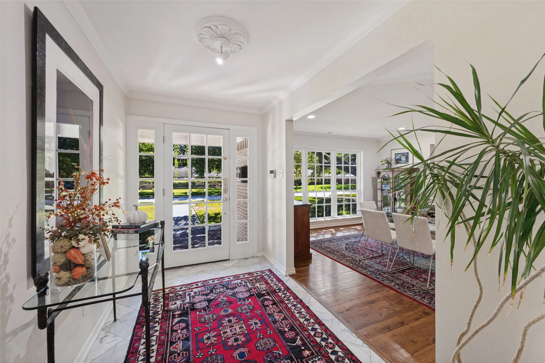 Entryway with a French door, transom windows, and crown molding