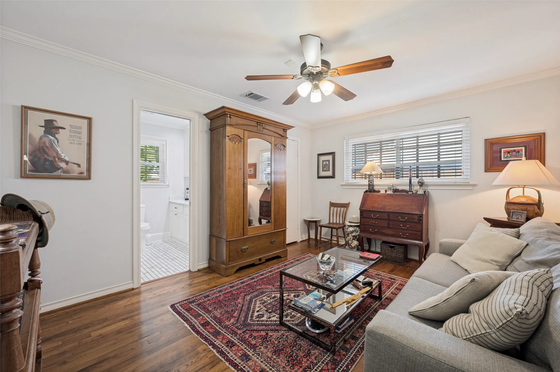 Hardwood flooring throughout, crown molding, ceiling fan, and recessed window with blinds