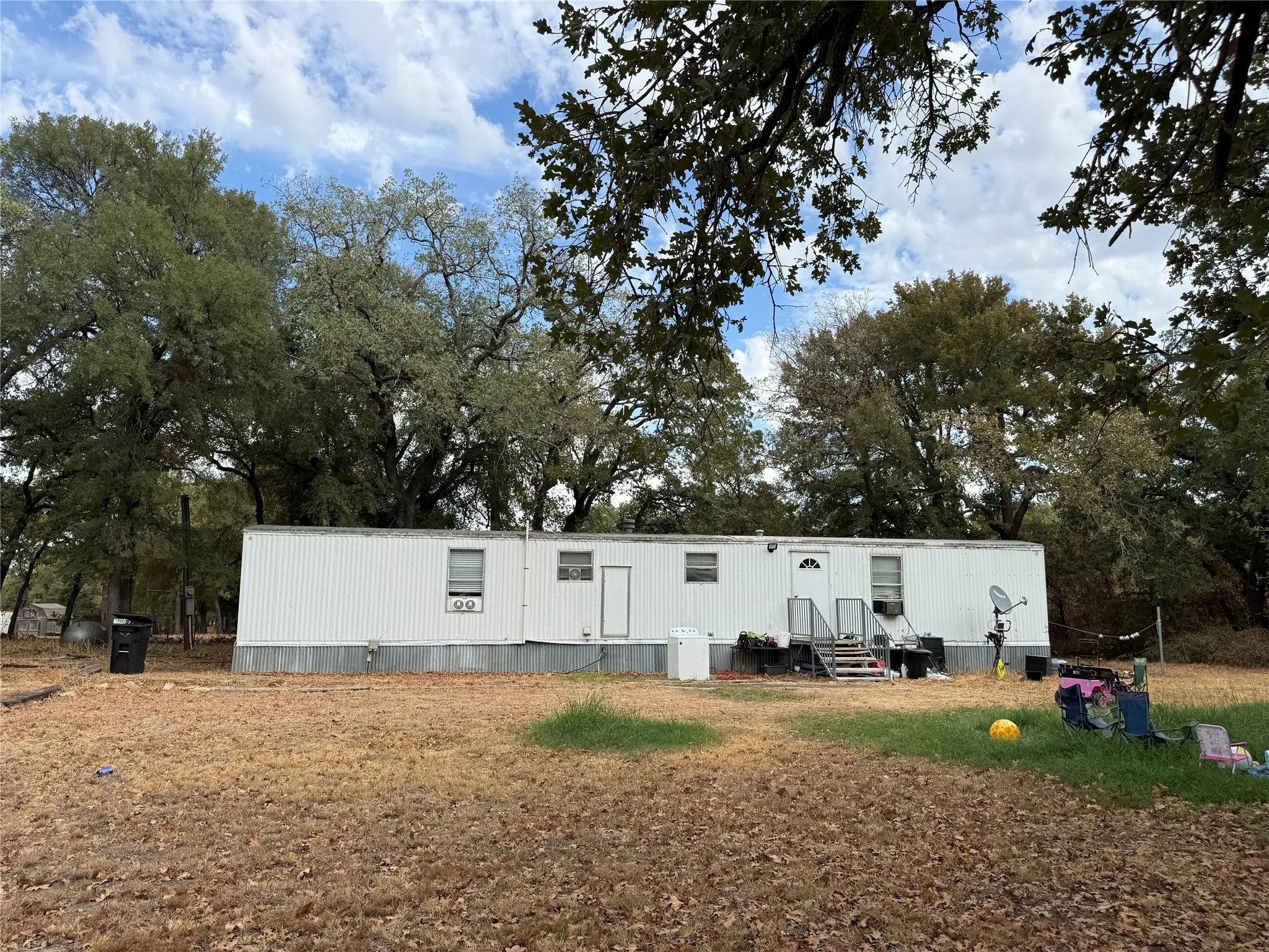 Spacious mobile home situated on expansive grounds with mature tree coverage
