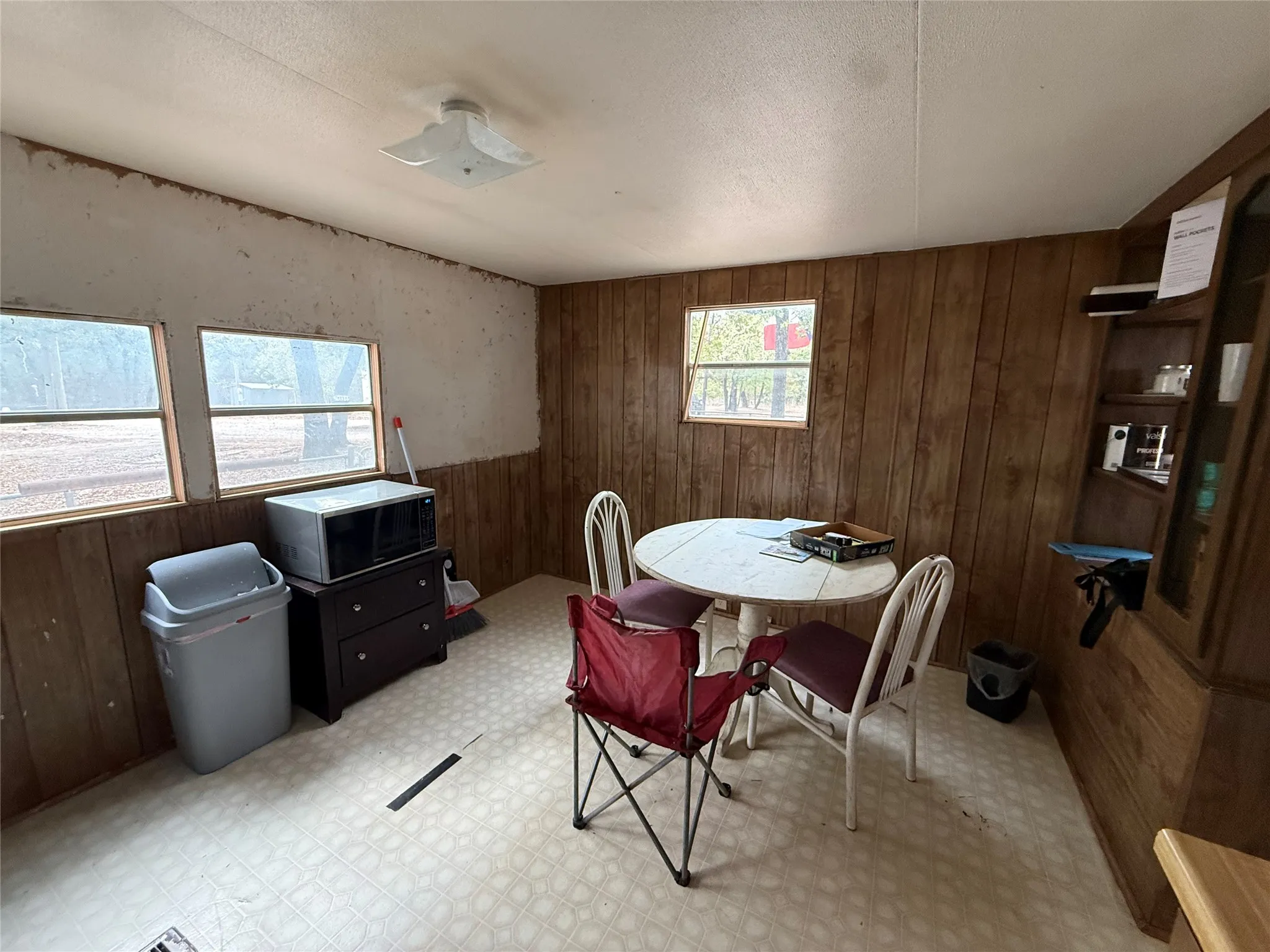 Interior space featuring wood-finish paneling, multiple windows, a ceiling-mounted light fixture, and patterned flooring