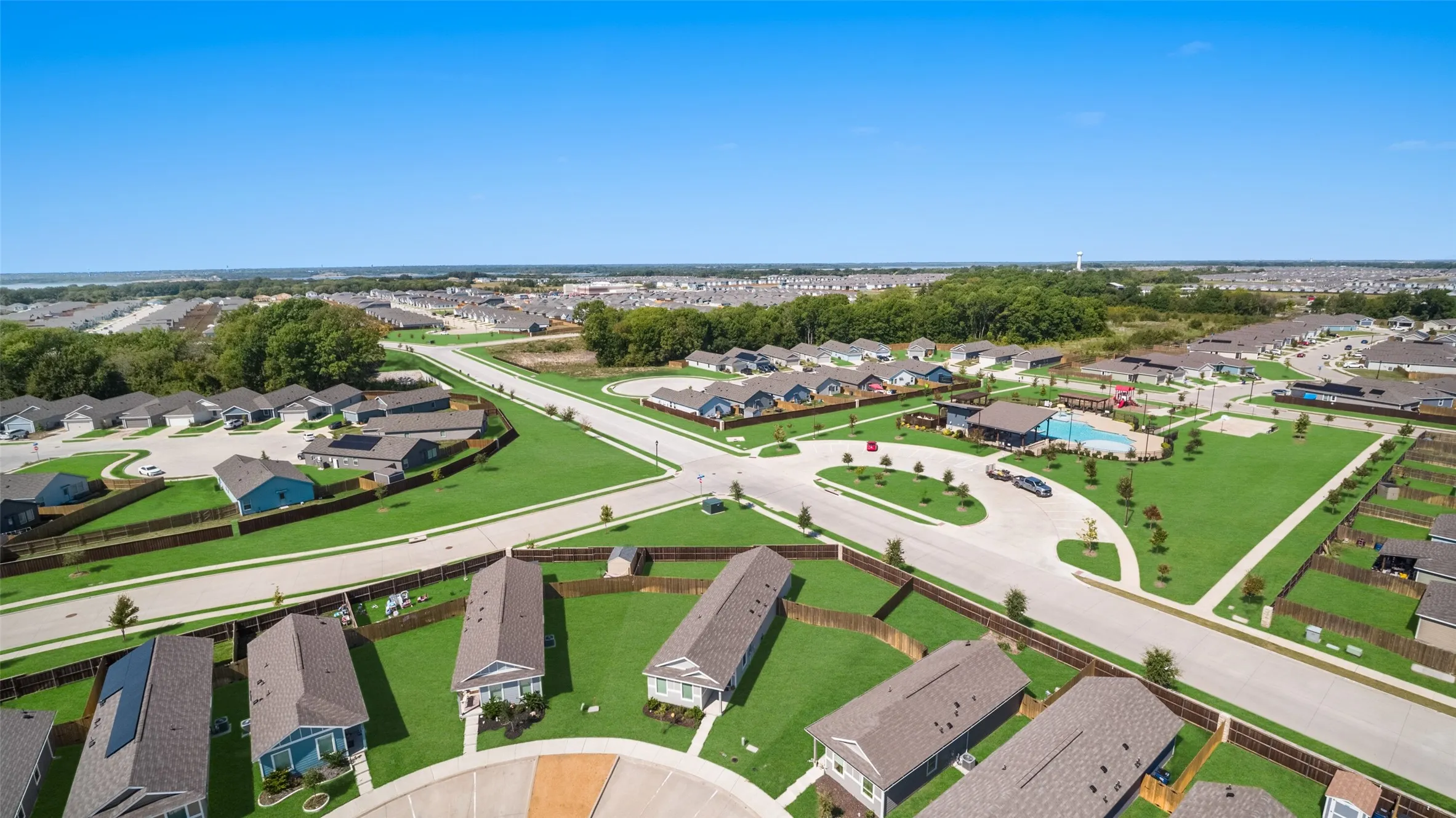 Community with a central amenity center, outdoor swimming pool, and dedicated green spaces
