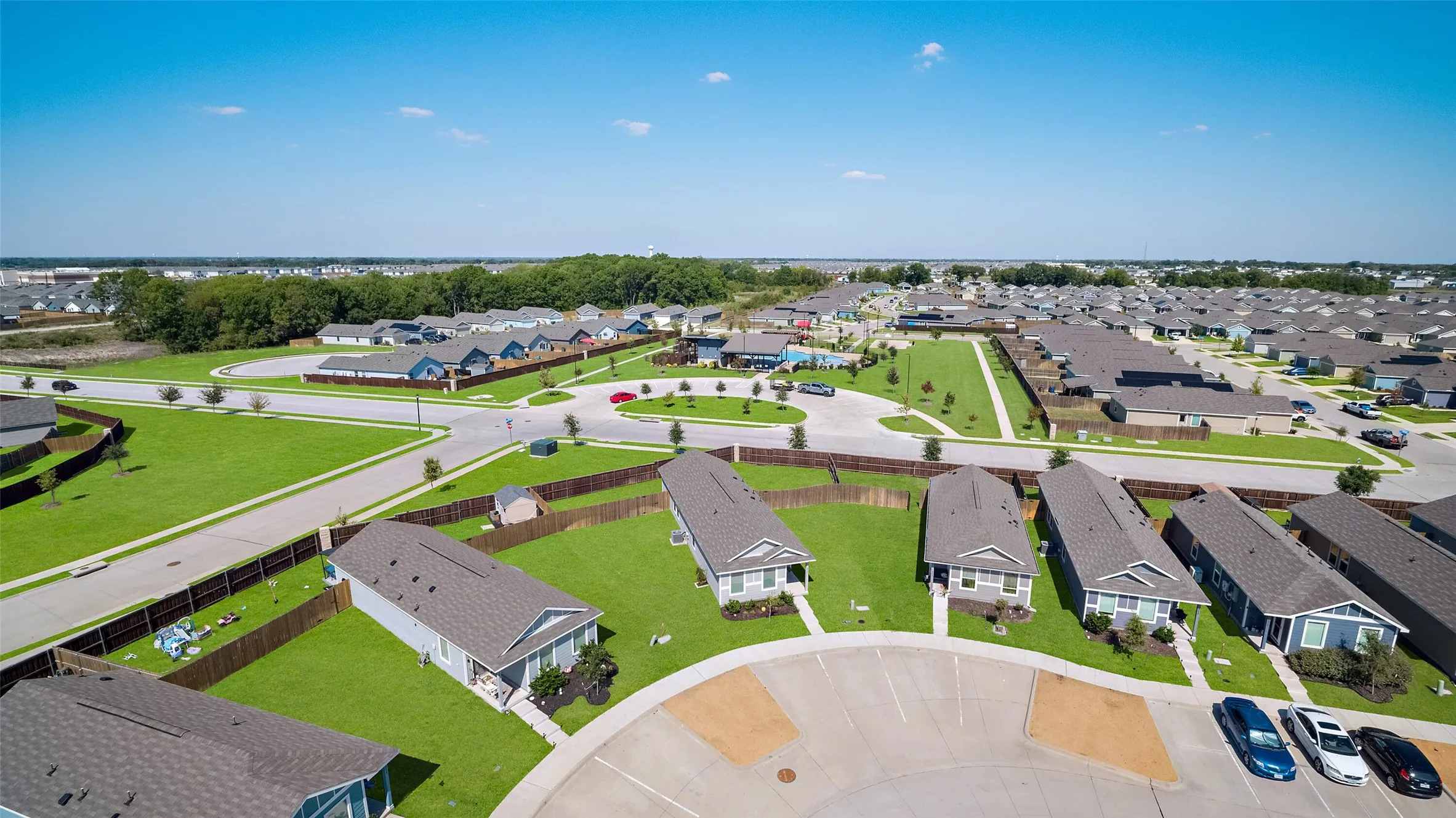 Residential neighborhood featuring single-story homes, paved streets, and green lawns