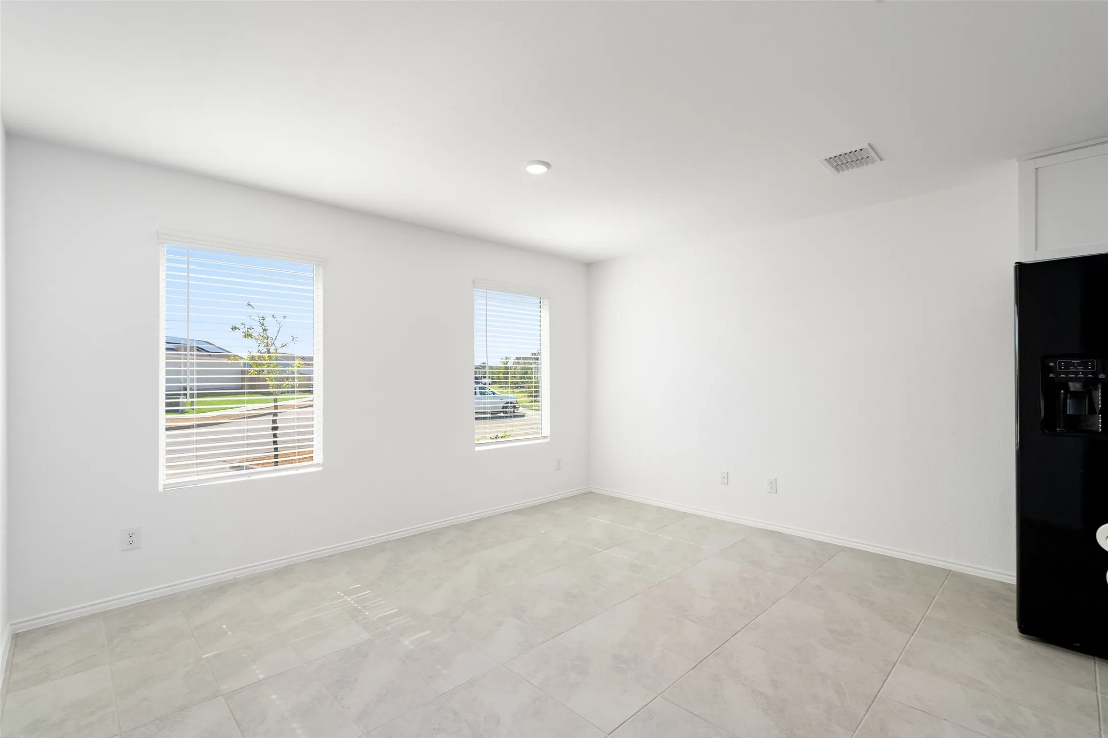 Recessed lighting, tile flooring, and two windows with blinds