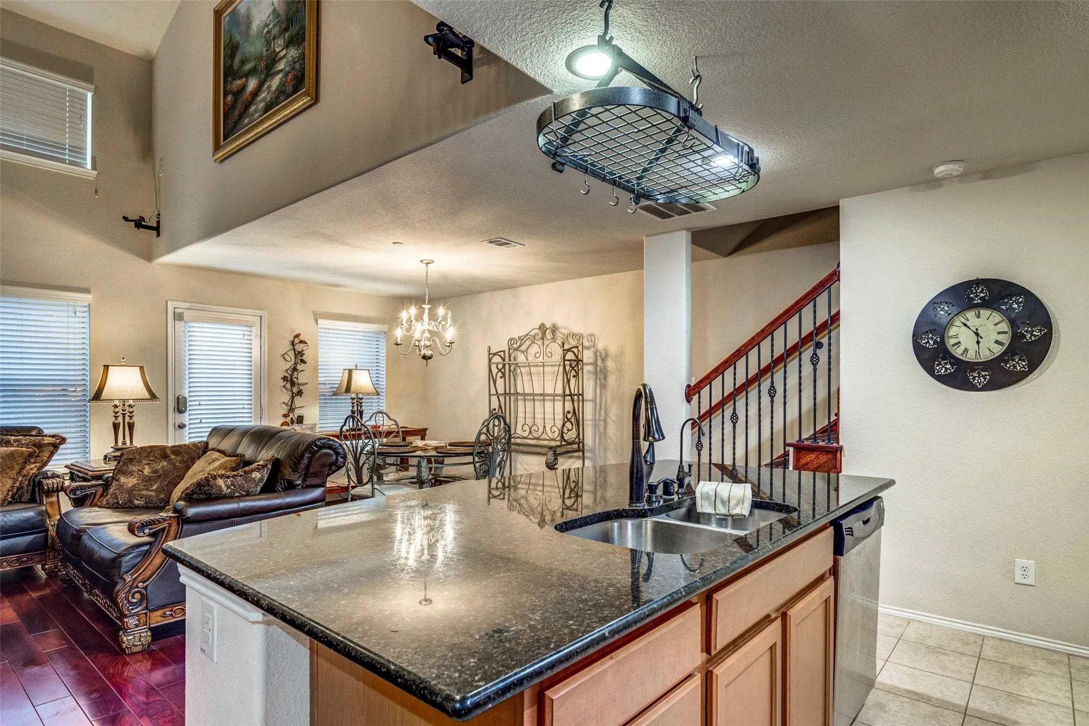 Kitchen island with dark granite countertop and stainless steel sink