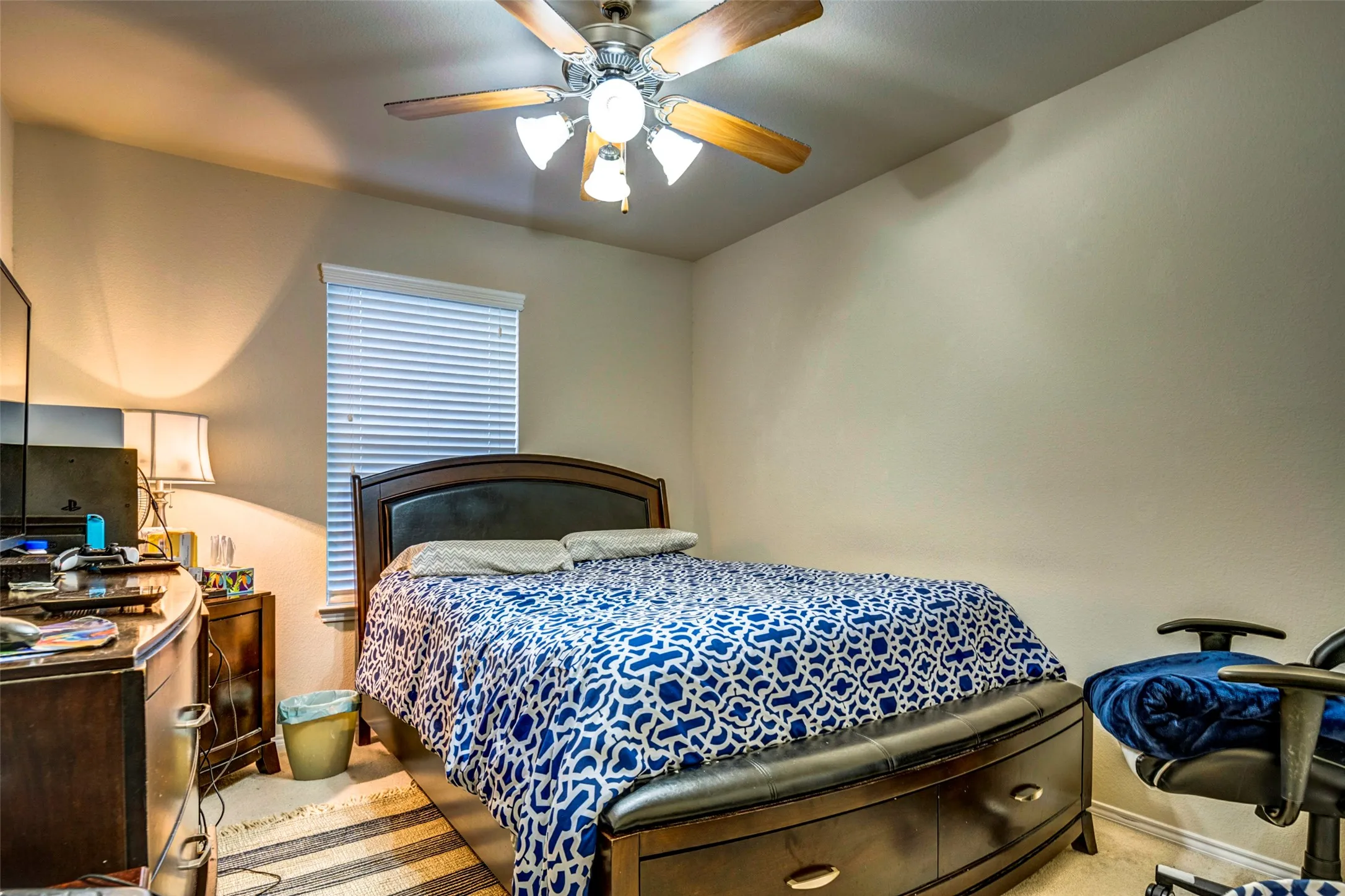 Neutral wall paint, ceiling fan with integrated lighting, and window with blinds