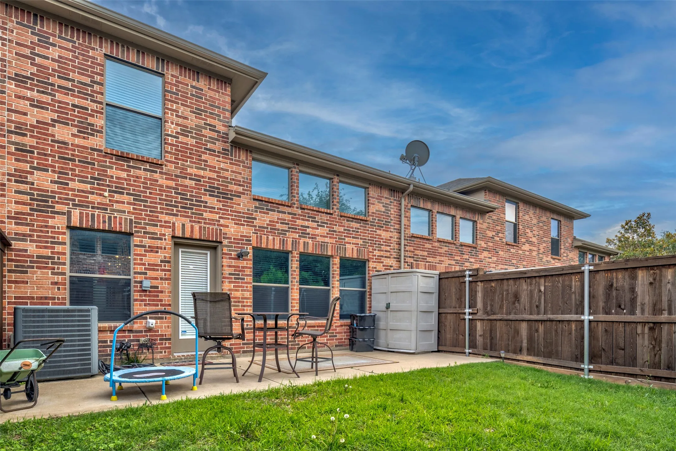 Expansive backyard retreat featuring a manicured lawn, composite patio space, and wood-finish privacy fencing