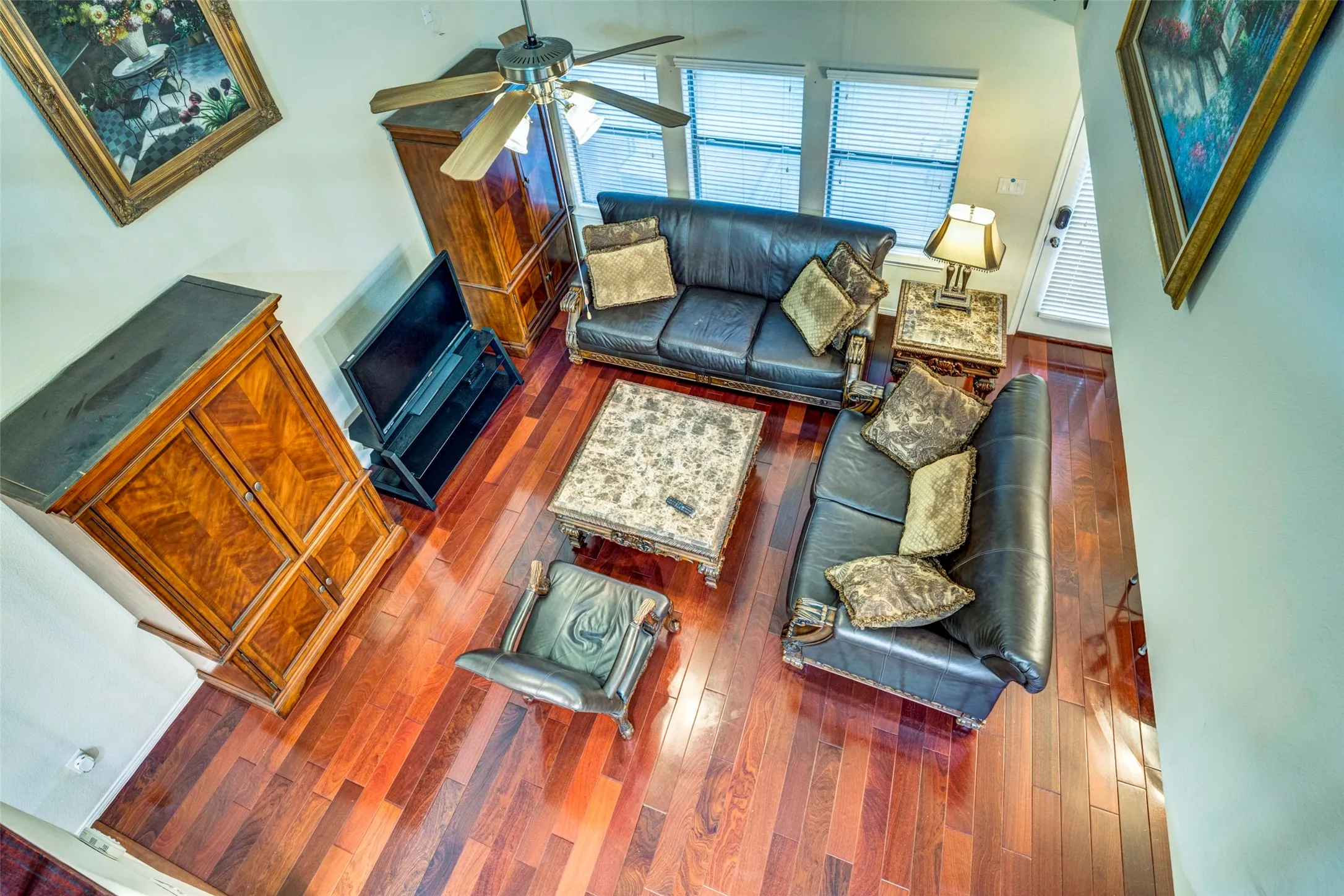Wood-finish flooring throughout, with a ceiling fan
