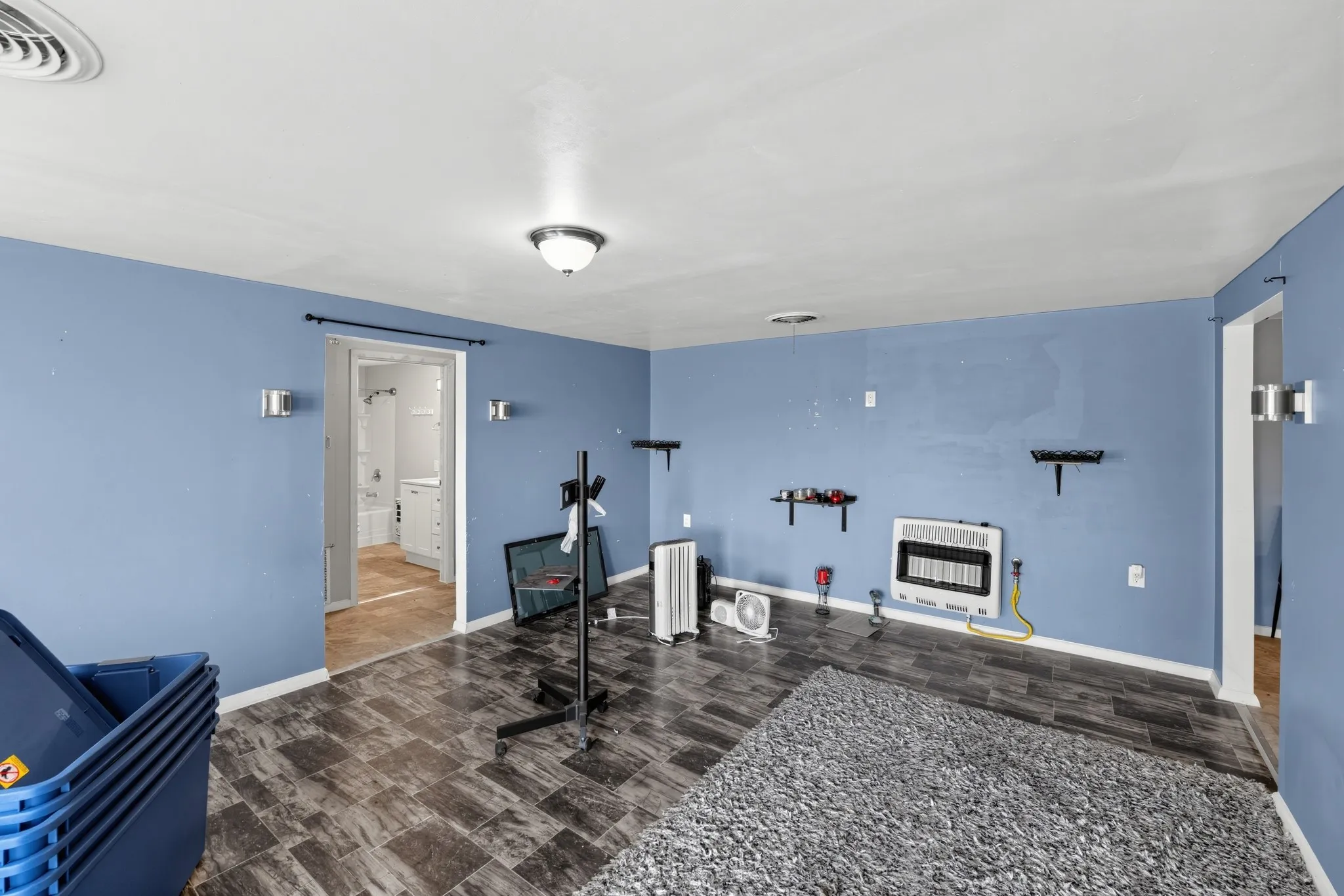 Recessed ceiling light, wall-mounted sconces, and durable tile flooring