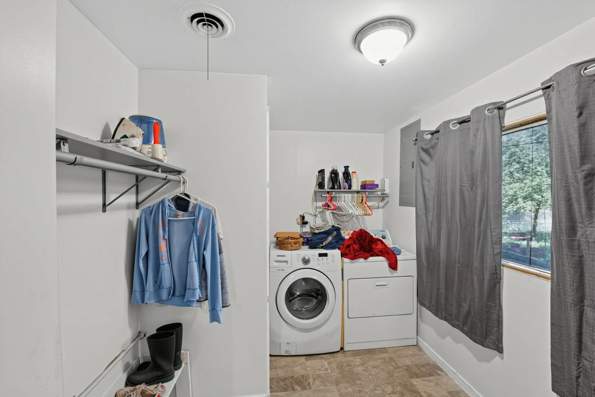 Laundry area featuring a window, built-in shelving, and a ceiling-mounted light fixture