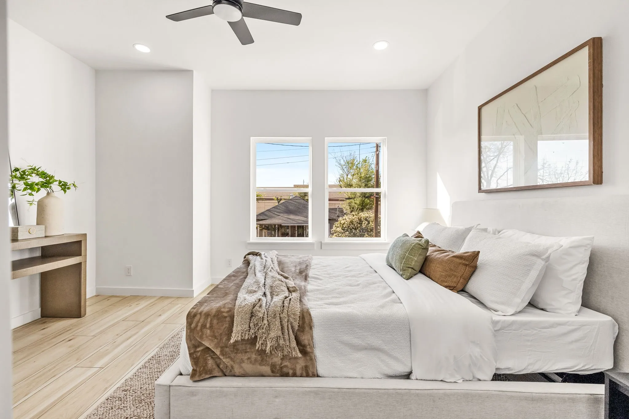 Light wood-finish flooring, recessed lighting, ceiling fan, and two windows