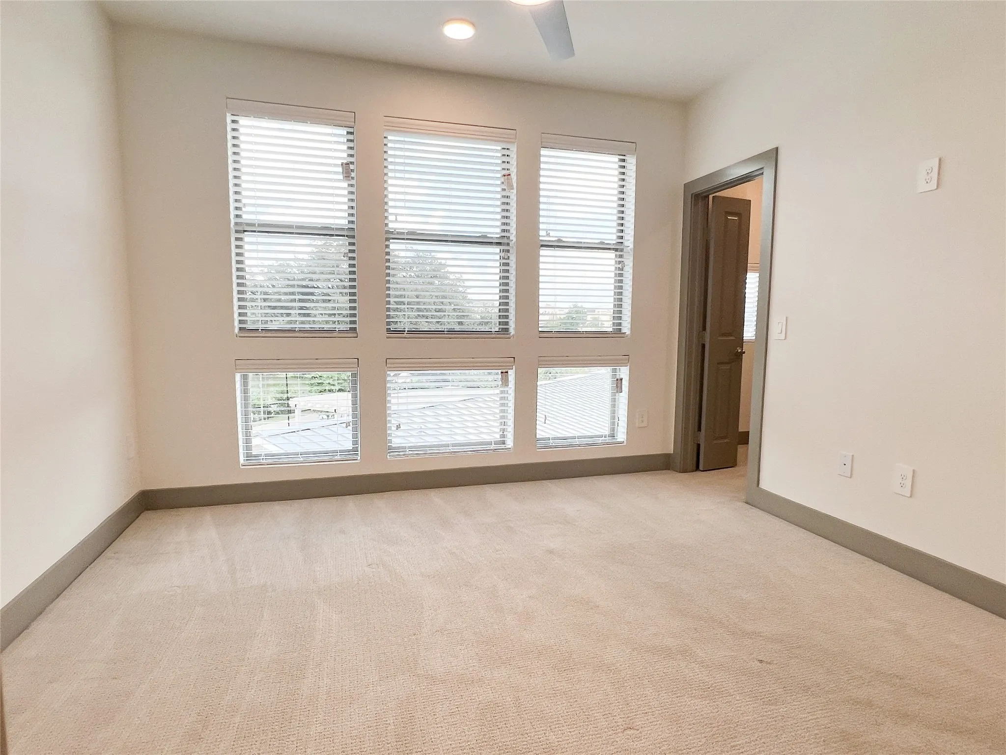 Unfurnished room with plenty of natural light, light carpet, ceiling fan, and recessed lighting