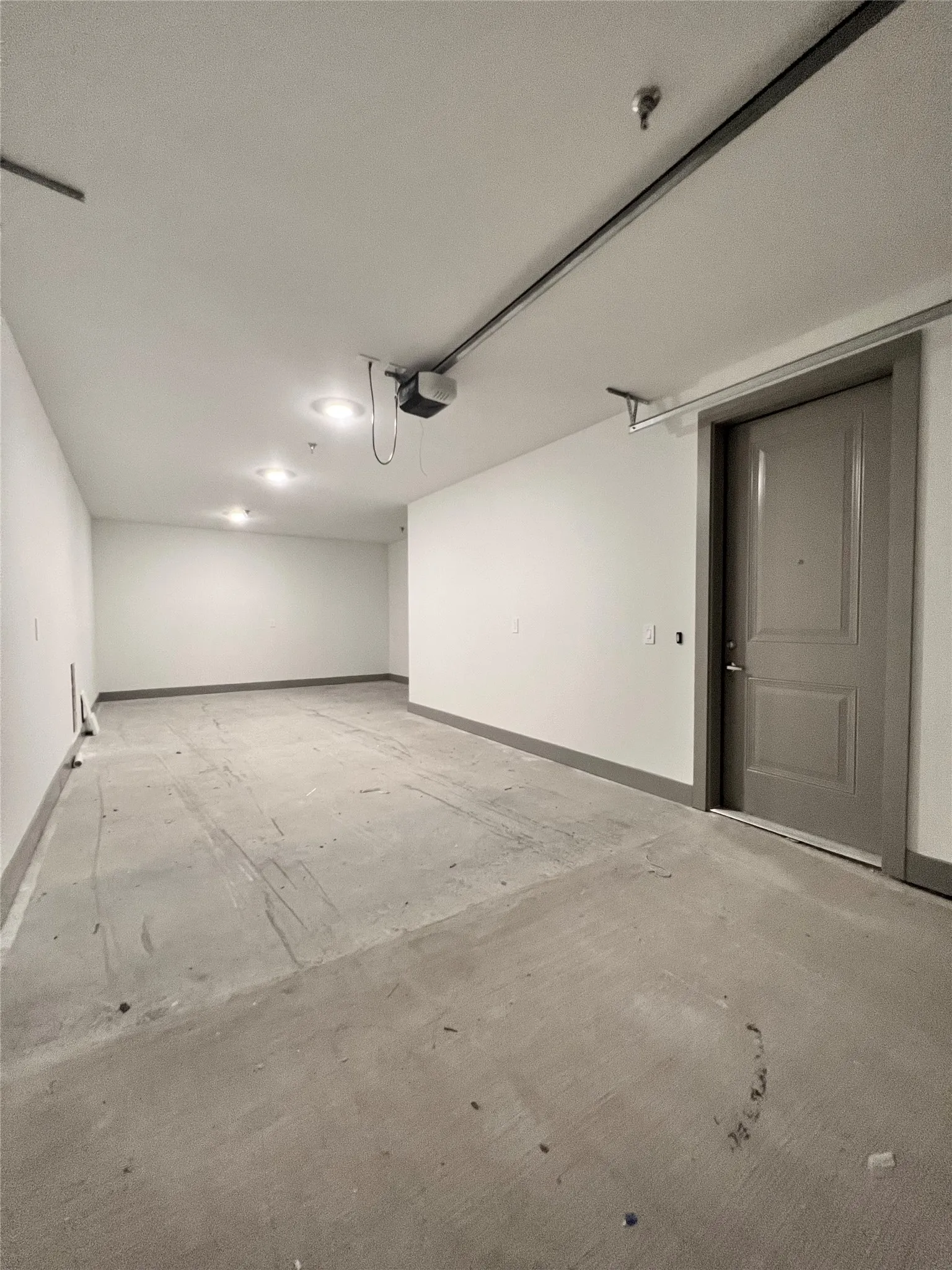 Garage featuring baseboards and a garage door opener