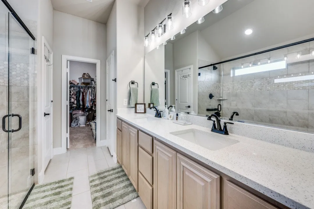 Dual vanity with integrated sinks, light-toned cabinetry, and a quartz-finish countertop