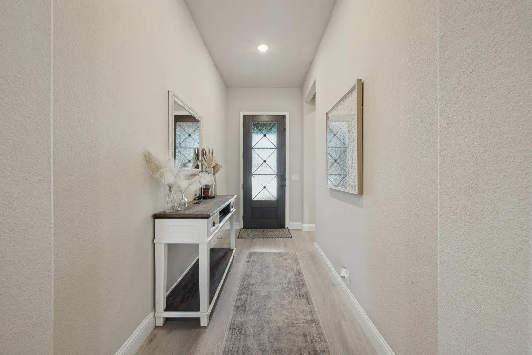 Recessed lighting illuminates wood-finish flooring