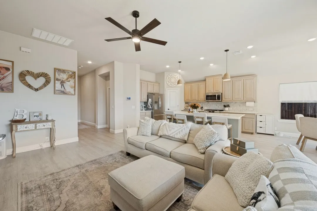 Open-concept living space featuring wood-finish flooring, recessed lighting, and a ceiling fan