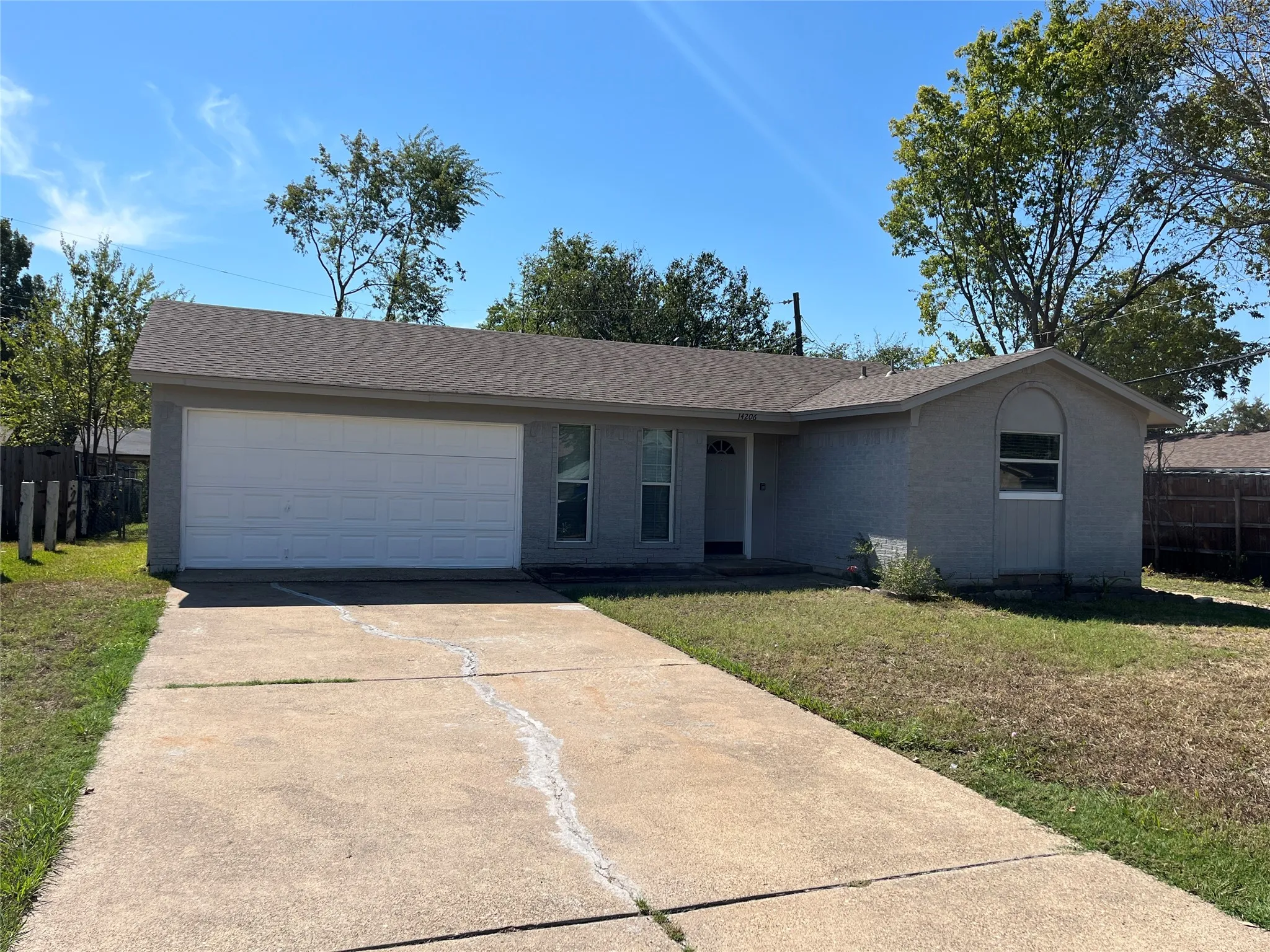 Single-story residence with a two-car garage, concrete driveway, and a shingled roof